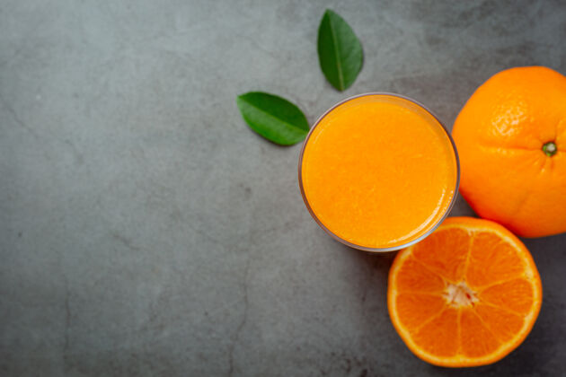 食物新鲜的橙汁在黑暗的背景玻璃柑橘切片果汁