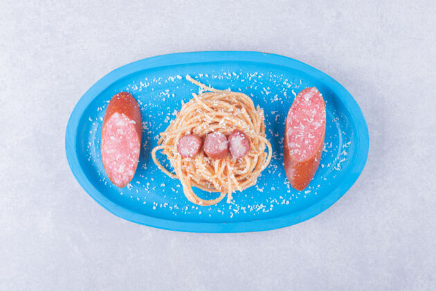 意大利面蓝色盘子上有香肠的美味意大利面佳肴食物香肠