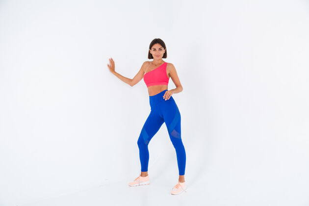 锻炼适合皮肤黝黑的运动型女性 拥有腹肌 健康曲线 穿着上衣和白色蓝色紧身裤活跃年轻动机