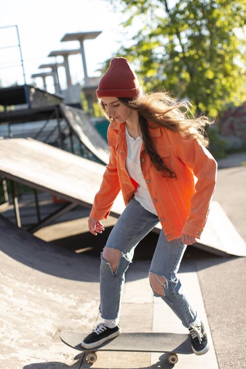 运动在外面溜冰的年轻女孩？全速射击滑板时尚街头