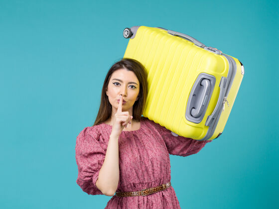 成人正面图：年轻女子带着她的大袋子在蓝色背景上度假夏季旅行女子海上度假旅行年轻女子旅程航程