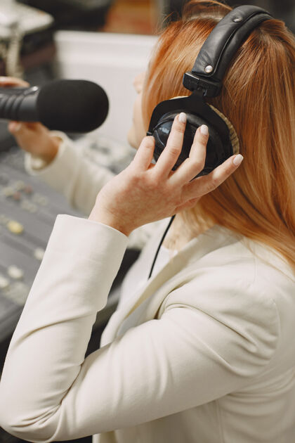 耳机女主持人用麦克风交流广播室里的女人工作场所新闻广播