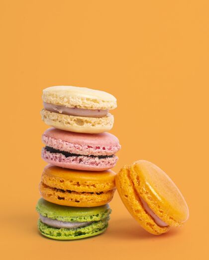 糕点五颜六色的平衡杏仁饼与黄色的垂直镜头蛋糕配料堆栈