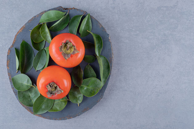 多汁新鲜柿子叶子贴在木板上的特写照片抗氧化美食素食