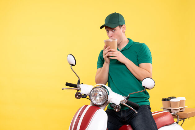 摩托车正面图身着制服的男信使手里拿着一个黄色的咖啡杯车辆制服自行车