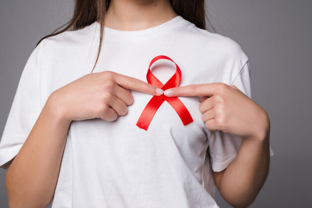 意识世界乳腺癌日的概念 保健-妇女穿白色t恤与粉红丝带的认识 象征性的蝴蝶结颜色提高人们对妇女乳腺肿瘤疾病的生活帮助人疾病
