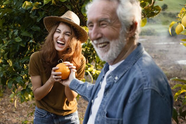 柑橘一个女人拿着一个新鲜的橘子和她的爸爸美味热带柑橘树