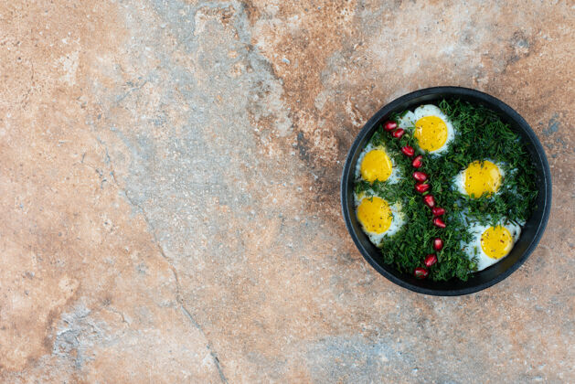 绿色带煎蛋卷和绿色蔬菜的深色平底锅俯视图深色食物大理石