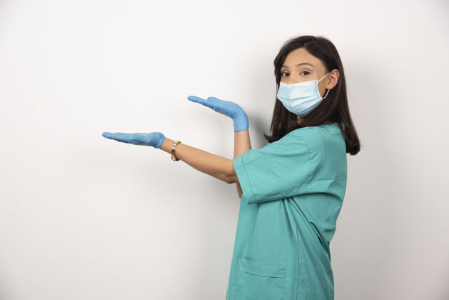 工人戴着医用面罩和手套的年轻医生站在白色背景上高质量照片女性妇女健康