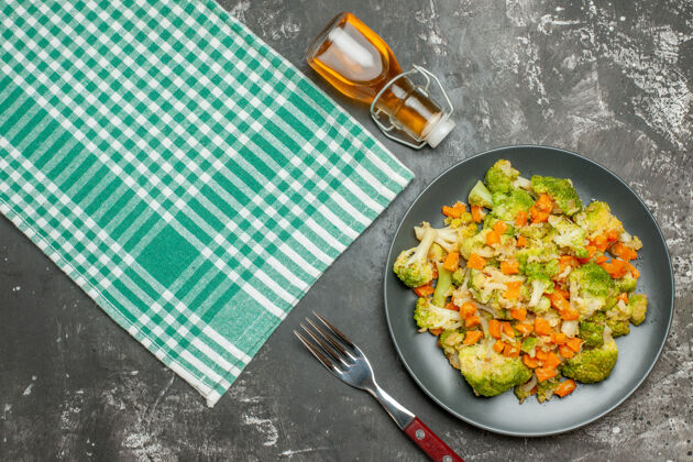 酒瓶新鲜健康的蔬菜沙拉 绿条毛巾和掉落的油瓶俯视图洋葱新鲜蔬菜