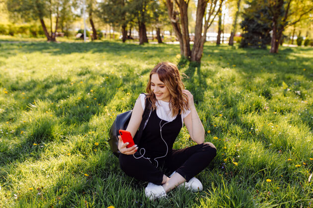 漂亮一个积极开朗的少女花时间在公园和使用手机的照片科技使用休闲