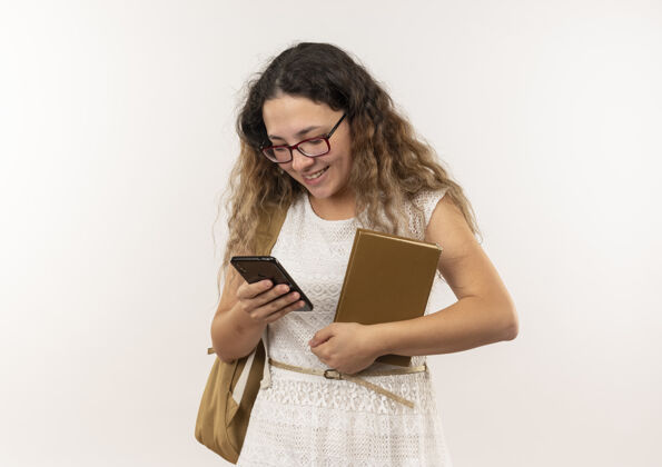 衣服面带微笑的年轻漂亮的女学生戴着眼镜 背着书包 用手机隔着墙人微笑人
