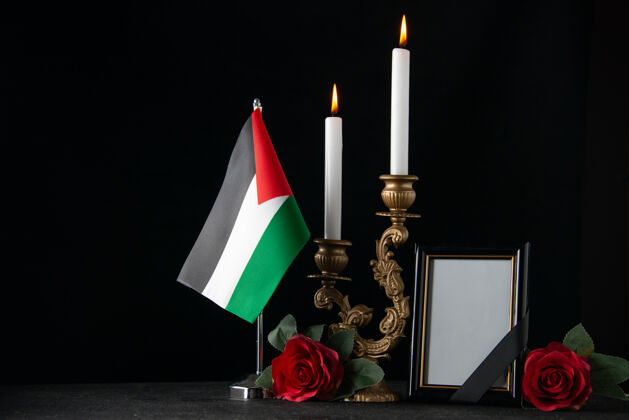 火前视图燃烧着巴勒斯坦国旗和相框黑暗的表面蜡烛正面框架火焰