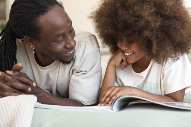 室内女儿和爸爸一起看书女孩娱乐休闲