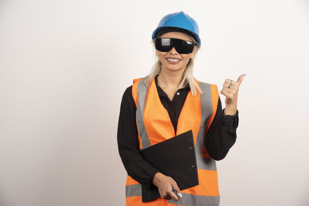 工程师戴眼镜的女工程师在白色背景上竖起大拇指高质量照片头盔微笑女人