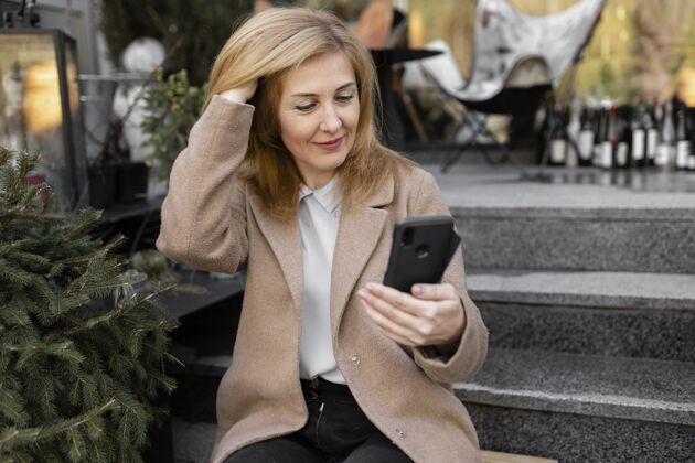 城镇快乐的中年妇女正在检查她的手机人爱情生活方式