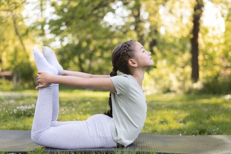 练习在户外瑜伽垫上锻炼的全镜头女孩健康活跃训练