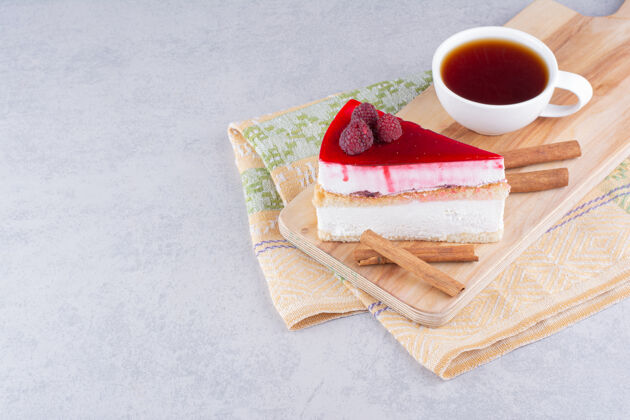肉桂芝士蛋糕和一杯红茶放在木板上水果糕点块