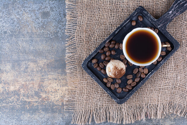 马克杯一杯有香味的咖啡 咖啡豆放在深色的木板上谷物芳香的板子