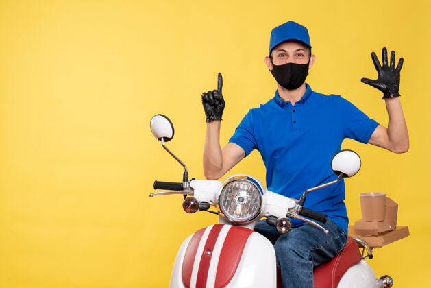 摩托车正面图：身穿蓝色制服 戴着黄色背景面具的年轻男性信使送货病毒工作