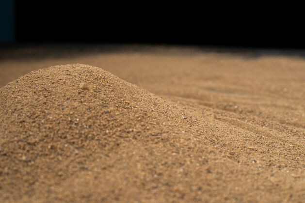 泥土黑色墙壁上的棕色沙子表面石头棕色质地