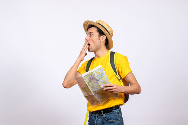 风景正面图：戴草帽 穿着黄色t恤的年轻人拿着地图人站着地图