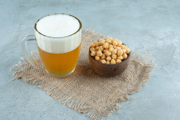 麻布一大杯啤酒 麻布上放满豌豆的小木碗高品质照片酒精清淡蔬菜