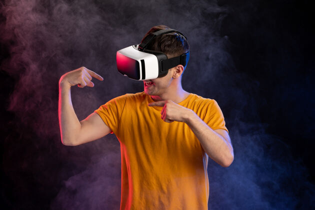 视觉帅哥戴着虚拟现实耳机在黑暗的表面肖像虚拟现实