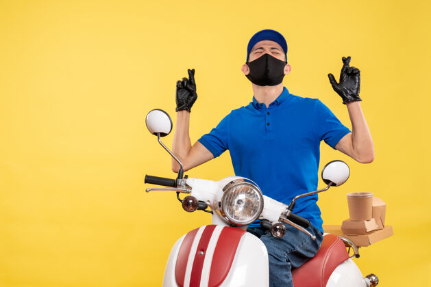 年轻男性信使正面图黄色背景下戴着面罩骑自行车的年轻男性信使送货视图制服