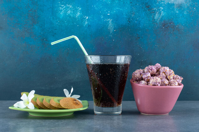 杯子小吃一套切片猕猴桃 一杯可乐和一碗蓝色的爆米花糖猕猴桃碗水果