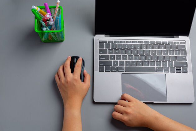 国际女人在家里用笔记本电脑工作 左手拿着电脑鼠标骄傲手写写作