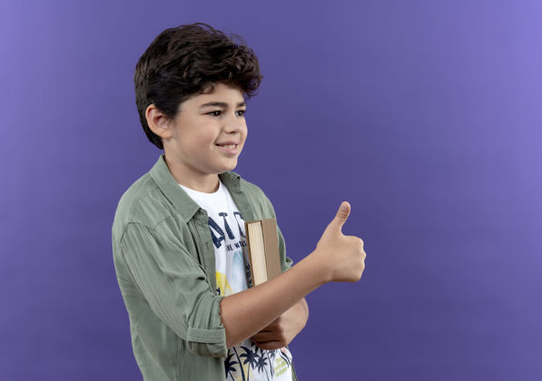 拇指看着旁边微笑着的小男孩 他举着大拇指拿着书紫色侧身小男孩