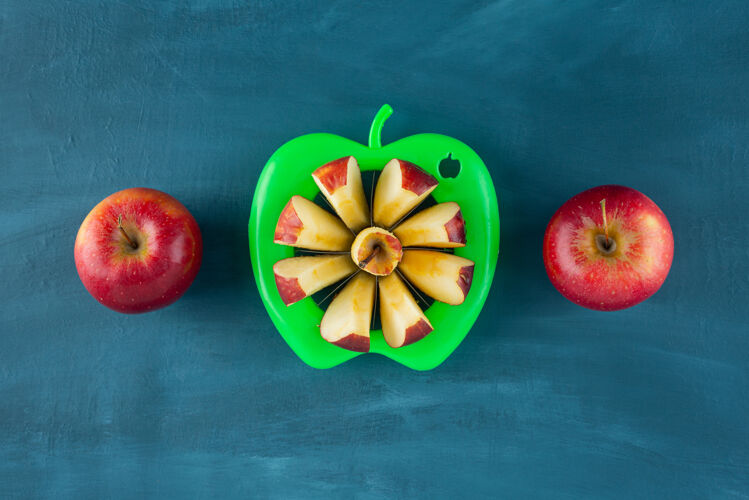 新鲜新鲜切成片的红苹果放在蓝色的表面上切片的成熟的营养