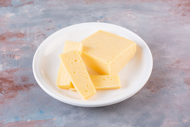 小吃白色的黄色奶酪片放在大理石表面切营养好吃