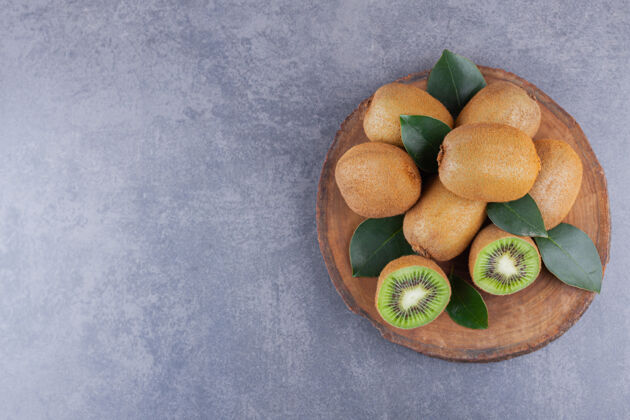 猕猴桃把整个猕猴桃和切片的猕猴桃放在石桌上切块可口水果