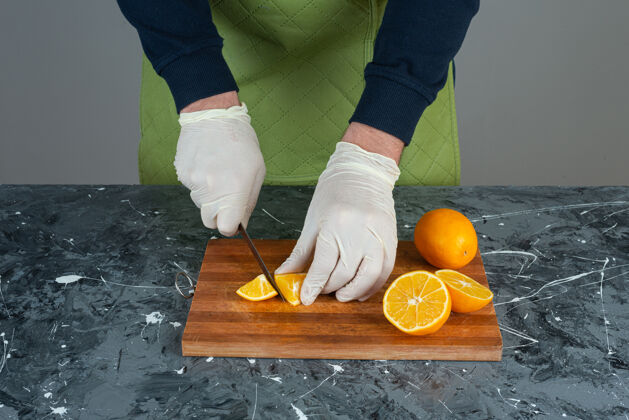 厨师男人的手在大理石桌上切新鲜的柠檬橘子手男