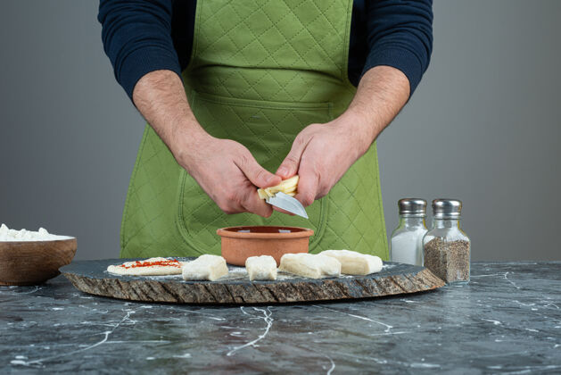 手工制作男人戴着手套在大理石桌上做面团糕点准备烘焙