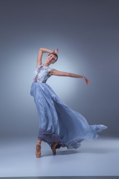 女孩美丽的芭蕾舞演员在蓝色背景上穿着蓝色长裙跳舞成人点灵感