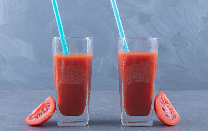 饮食两杯新鲜番茄汁和灰色背景的番茄片玻璃配料健康