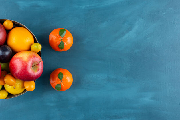 天然一碗各种新鲜水果放在蓝色的背景上异国情调健康分类