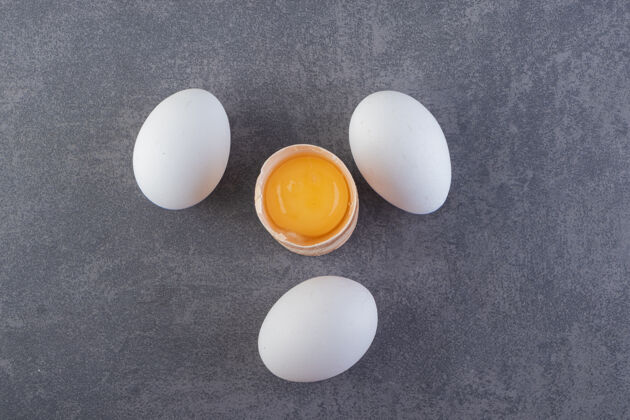 生的把新鲜的生鸡蛋放在石头上未经料理的鸡肉母鸡