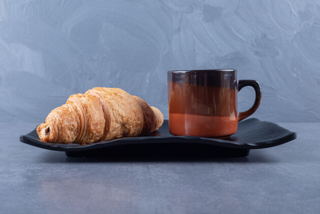新鲜一杯黑咖啡和羊角面包作为早餐 灰色背景蜂蜜咖啡美味