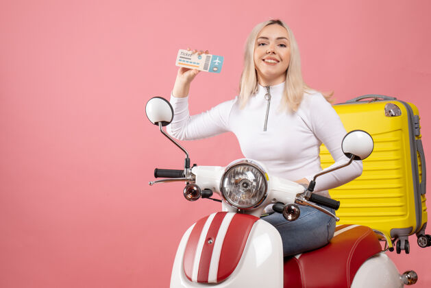 车辆正面图：坐在轻便摩托车上微笑的年轻女士出示车票摩托车微笑的年轻女士轻便摩托车