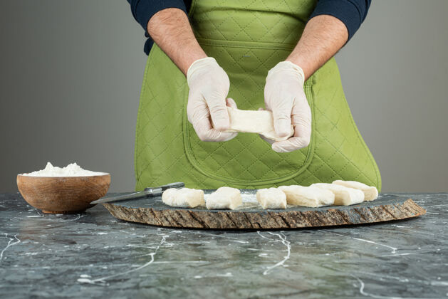 面包师男人戴着手套在大理石桌上做面团烘焙人生的