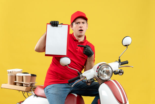 举行一个穿着红色上衣 戴着帽子手套 戴着医用面罩 坐在摩托车上拿着文件的快递员的正视图面罩滑板车帽子