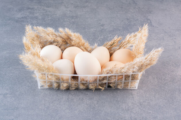 蛋石桌上放着新鲜生的白鸡蛋和麦穗鸡食物未经料理的