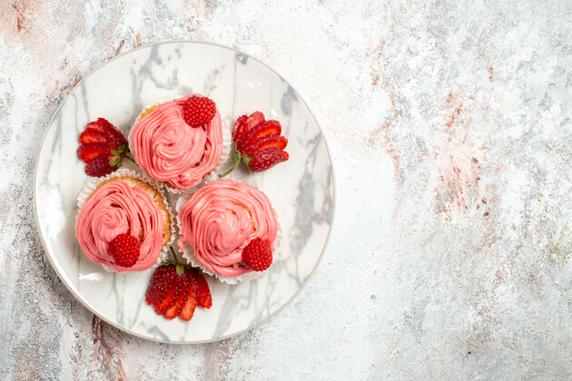 草莓白色表面上有新鲜的红色草莓的粉色草莓蛋糕俯视图新鲜甜点桌子