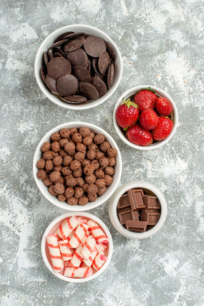 营养在灰白色的地面上 可近距离观看带有糖果 草莓 巧克力 谷类食品和可可的碗 并提供自由空间膳食碗水果