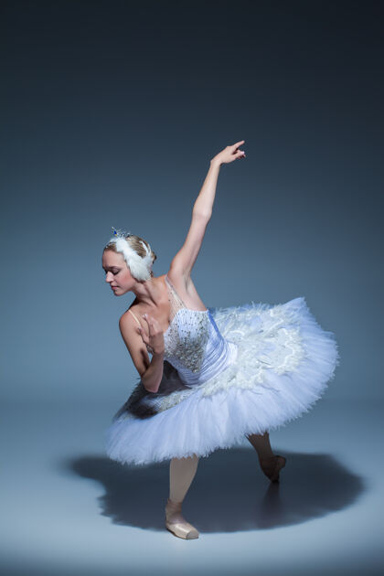 女性芭蕾舞演员在蓝色背景下扮演白天鹅的肖像女演员戏剧经典