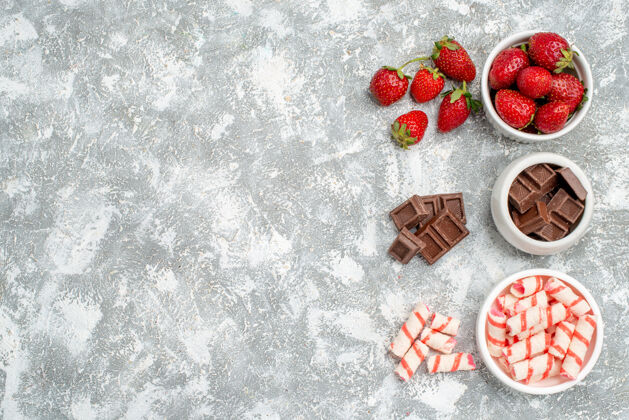 水晶顶视图碗草莓巧克力糖果和一些草莓巧克力糖果在灰白色的地面右侧巧克力庆典地面